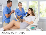 Male beautician, together with a nurse, examines face of an young woman and plans facelift procedures. Стоковое фото, фотограф Яков Филимонов / Фотобанк Лори