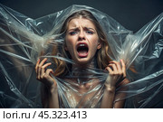 The girl is wrapped in cellophane or a bag. The girl is suffocating. Plastic pollution of the planet. Environmental hazard. Reducing the reuse of plastic. Recycling. The concept of garbage. Стоковое AI-изображение, AI-художник Photojuli / Фотобанк Лори