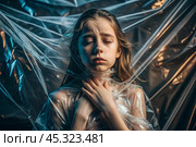 The girl is wrapped in cellophane or a bag. The girl is suffocating. Plastic pollution of the planet. Environmental hazard. Reducing the reuse of plastic. Recycling. The concept of garbage. Стоковое AI-изображение, AI-художник Photojuli / Фотобанк Лори