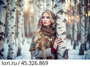 A beautiful girl in a traditional Russian folk shawl in a winter birch grove. The portrait symbolizes the traditions and beauty of the Russian people. Стоковое AI-изображение, AI-художник Photojuli / Фотобанк Лори