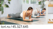Young woman holding forearms plank pose in yoga studio. Стоковое фото, фотограф Яков Филимонов / Фотобанк Лори