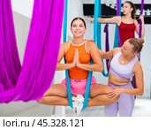 Woman practicing antigravity yoga with personal trainer. Стоковое фото, фотограф Яков Филимонов / Фотобанк Лори