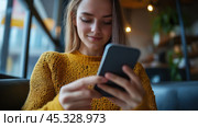 молодая девушка наслаждается перерывом на кофе, одновременно используя смартфон. Стоковое AI-изображение, AI-художник ФотоИнтеллект / Фотобанк Лори