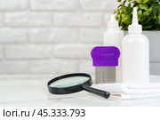 Lice treatment product next to a nit comb and magnifying glass. Стоковое фото, фотограф Сергей Толмачёв / Фотобанк Лори
