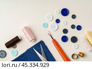 Sewing supplies and denim fabric arranged on a workspace for clothing alterations in a bright setting. Стоковое фото, фотограф Сергей Толмачёв / Фотобанк Лори
