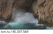 Sea waves enter a cave in rock and form splashes. Стоковое видео, видеограф Михаил Коханчиков / Фотобанк Лори
