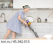 Housewife does cleaning in room - vacuums and dusts. Стоковое фото, фотограф Яков Филимонов / Фотобанк Лори