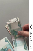 Vertical video of men's hands counting paper money Russian rubles of different denominations. Banknotes of 5000, 1000 and 500 rubles fall on a light table. Flat lat, close-up, top view, copy space, mock up. Стоковое видео, видеограф Виктория Катьянова / Фотобанк Лори