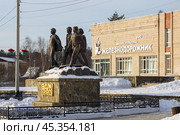Памятник «БАМ — дорога дружбы», город Северобайкальск, Республика Бурятия, Сибирь, Россия. Памятник, посвящённые строителям Байкало-Амурской магистрали, около здания дворца культуры «Железнодорожник». На фасаде ДК логотип РЖД (Российские железные дороги). Достопримечательности Северобайкальска. Редакционное фото, фотограф Андрей Степанов / Фотобанк Лори