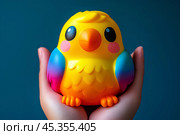 Яркая разноцветная игрушка в ладонях. Стоковое AI-изображение, AI-художник Щеголева Ольга / Фотобанк Лори