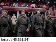 Люди в форме солдат времен Великой Отечественной войны идут по Красной площади в центре города Москвы на фоне Московского кремля, Россия. Редакционное фото, фотограф Николай Винокуров / Фотобанк Лори