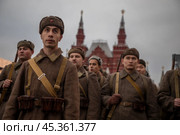 Люди в форме солдат и с оружием Великой Отечественной войны идут по Красной площади в центре города Москвы на фоне Московского кремля, Россия. Редакционное фото, фотограф Николай Винокуров / Фотобанк Лори