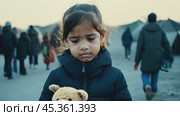 Heartbroken refugee child holding a teddy bear in a crowded camp. Стоковое видео, видеограф Данил Руденко / Фотобанк Лори