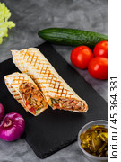Delicious chicken shawarma with  sauce, vegetables  on a cutting board. Стоковое фото, фотограф Виталий Сова / Фотобанк Лори
