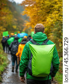 Man in green jacket with backpack joins a group hike through vibrant autumn forest, AI. Стоковое AI-изображение, AI-художник Сергей Старуш / Фотобанк Лори