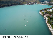 Panoramic aerial view of the mountain lake and coastal area with architecture and infrastructure of the Abrau-Durso resort village. Shooting from a drone. Стоковое фото, фотограф Роман Дзюбало / Фотобанк Лори