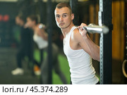 Determined young guy working out with weight rod during crossfit workout. Стоковое фото, фотограф Яков Филимонов / Фотобанк Лори