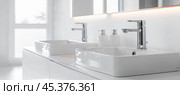 Modern white bathroom sinks with chrome faucets displaying contemporary design. Стоковое AI-изображение, AI-художник Юрий Поздников / Фотобанк Лори