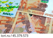Купюры достоинством 5000 рублей и карта платежной системы МИР крупным планом (2024 год). Редакционное фото, фотограф Косиненко Юрий / Фотобанк Лори