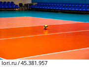 Orange volleyball court in sport hall with ball, poster, no one. Professional volleyball courts in sport gym at chairs backdrop. Team game success, healthy sporty lifestyle concept. Copy ad text space. Стоковое фото, фотограф Aleksandr Golubev / Фотобанк Лори