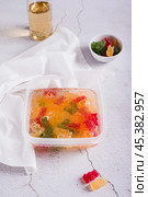 Marmalade candies are infused in lemonade for subsequent freezing in a container vertical view. Стоковое фото, фотограф Елена Руй / Фотобанк Лори