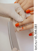 manicure worker smoothing customers nails with nail file. Стоковое фото, фотограф Сергей Толмачёв / Фотобанк Лори