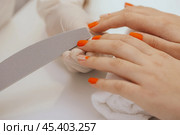 manicure worker smoothing customers nails with nail file. Стоковое фото, фотограф Сергей Толмачёв / Фотобанк Лори