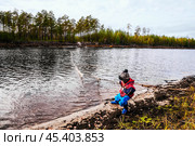 Мальчик с рыболовной сетью у реки. Его отец рядом, а он, познает мир - повторяет все движения отца . Их родовое имение находится в лесу ( недалеко от реки ). Они, коренные жители народов севера - ханты, здесь живут годами. Основные продукты - самые, что ни на есть натуральные. Все остальное покупают раз в месяц, в городе. Сообщение с городом круглый год по реке , километров 20-25... (2011 год). Редакционное фото, фотограф Павел Просянов / Фотобанк Лори