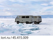 BAIKAL LAKE, OLKHON ISLAND, IRKUTSK REGION, RUSSIA - March 02, 2024: Tourists come in off-road cars SUVs to Cape Sagan-Khushun or Three brothers across ice of frozen Small Sea in winter. Редакционное фото, фотограф Виктория Катьянова / Фотобанк Лори