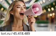 Pretty joyful girl speaks into megaphone on copy space. Announcement of sales in the shopping mall. Panorama. Close-up of woman face with bullhorn. Стоковое AI-видео, аниматор Igor Tichonow / Фотобанк Лори