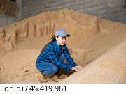Woman farmer checking quality of soybean husk. Стоковое фото, фотограф Яков Филимонов / Фотобанк Лори