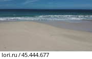 The ocean is calm and the sky is blue. The beach is empty and the waves are small. Стоковое видео, видеограф Дмитрий Брусков / Фотобанк Лори