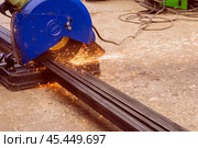 Cutting metal with a hand-held machine with a cutting disc when buying material in a store for building a new house. Стоковое фото, фотограф Акиньшин Владимир / Фотобанк Лори