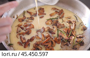 Process of cooking scrambled eggs in frying pan. Pieces of champignons and asparagus are added to dish. Hostess mixes dish with kitchen spatula, fry fried eggs with mushrooms. Стоковое видео, видеограф Яков Филимонов / Фотобанк Лори