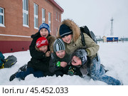 Самбург, Пуровский район,  Ямал,  Западная Сибирь, Россия - 21 Декабря, 2011:  Зима, морозный день, местные мальчишки во дворе школы дурачатся в снегу.  Самбург - самый Северный поселок Пуровского района, и здесь веками проживают в основном ненцы. Редакционное фото, фотограф Павел Просянов / Фотобанк Лори