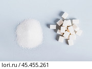 Alternative between lump sugar and granulated sugar on a blue background top view. Стоковое фото, фотограф Елена Руй / Фотобанк Лори