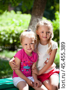 Two sisters family portrait on background of summer park. Стоковое фото, фотограф Андрей Аркуша / Фотобанк Лори
