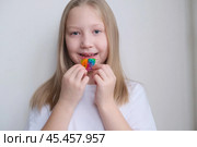 Детская зубная пластина радужного цвета. Ребенок держит в руках ортодонтическую пластинку, чтобы выровнять зубы и расширить челюсть. Стоковое фото, фотограф Терехова Марина / Фотобанк Лори