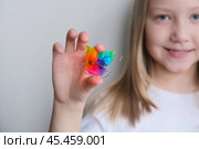 Детская зубная пластина радужного цвета. Ребенок держит в руках ортодонтическую пластинку, чтобы выровнять зубы и расширить челюсть. Стоковое фото, фотограф Терехова Марина / Фотобанк Лори