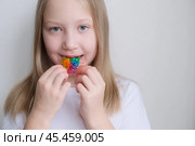 Детская зубная пластина радужного цвета. Ребенок держит в руках ортодонтическую пластинку, чтобы выровнять зубы и расширить челюсть. Стоковое фото, фотограф Терехова Марина / Фотобанк Лори