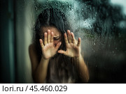 Sad, suffering woman pressed her palms against the window during the rain. Стоковое AI-изображение, AI-художник Дмитрий Киселёв / Фотобанк Лори