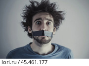 Shaggy, frightened man with his mouth taped shut. Стоковое AI-изображение, AI-художник Дмитрий Киселёв / Фотобанк Лори