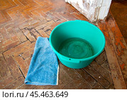 Таз для сбора капающей с потолка воды, стоящий на старом паркетном полу. Стоковое фото, фотограф Вячеслав Палес / Фотобанк Лори
