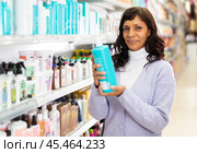 Latin american woman looking for haircare products at cosmetics shop. Стоковое фото, фотограф Яков Филимонов / Фотобанк Лори