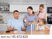 Angry wife with teenage daughters demanding money from upset man. Стоковое фото, фотограф Яков Филимонов / Фотобанк Лори