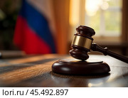 A judge's hammer with a stand on the background of the Russian flag and a window. Стоковое AI-изображение, AI-художник RamA / Фотобанк Лори