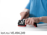 A knife sharpener. A man sharpens a knife on a special universal knife sharpener. Стоковое фото, фотограф Александр Поташев / Фотобанк Лори