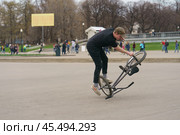 BMX in the Moscow park. Young man doing trick on the bike in the spring day. Extreme sports is very popular among youth. 2019. Редакционное фото, фотограф YuryKara / Фотобанк Лори