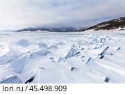 Winter landscape of frozen Baikal Lake. View of snow-covered ice hummocks with fragments of transparent ice floes in valley of Goloustnaya or Eden-Gol river delta. Natural background. Winter travels. Стоковое фото, фотограф Виктория Катьянова / Фотобанк Лори