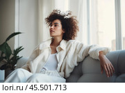 Sweet idleness. Lazy young hispanic lady sit in relaxed pose on big comfy sofa at living room interior breath air dream imagine. Successful female new flat apartment buyer rest at home feel pleasure. Стоковое AI-изображение, AI-художник Sergey Grishin / Фотобанк Лори